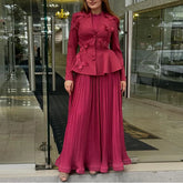 Woman in a pink outfit standing in front of a glass door.